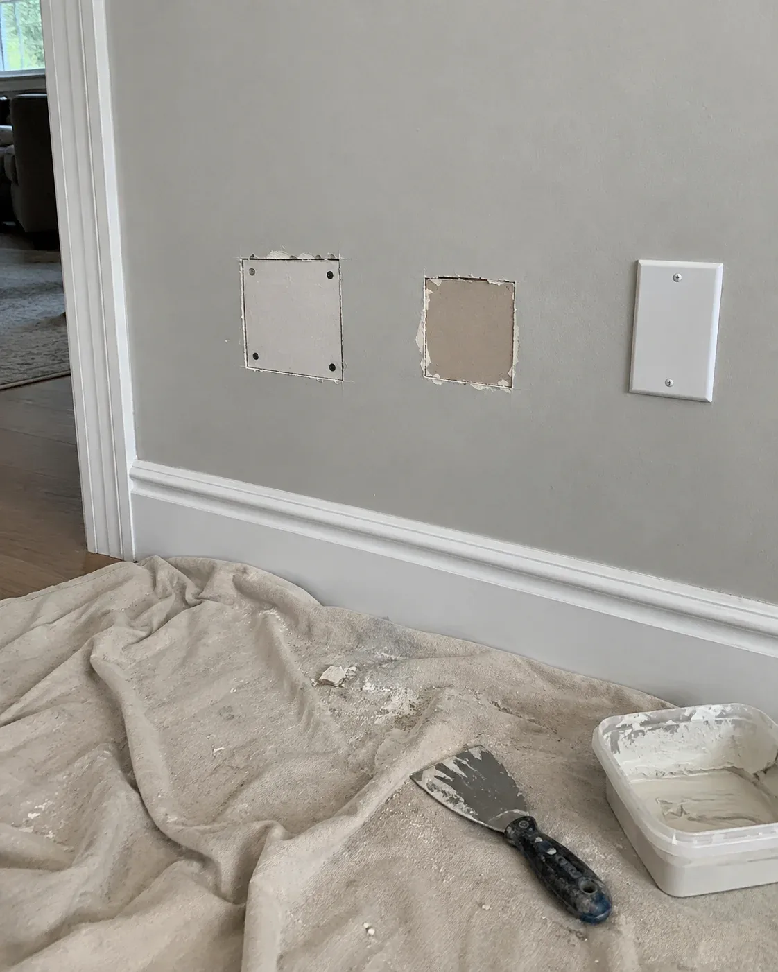 Wall access opening after electrical wiring work, prepared for drywall patching