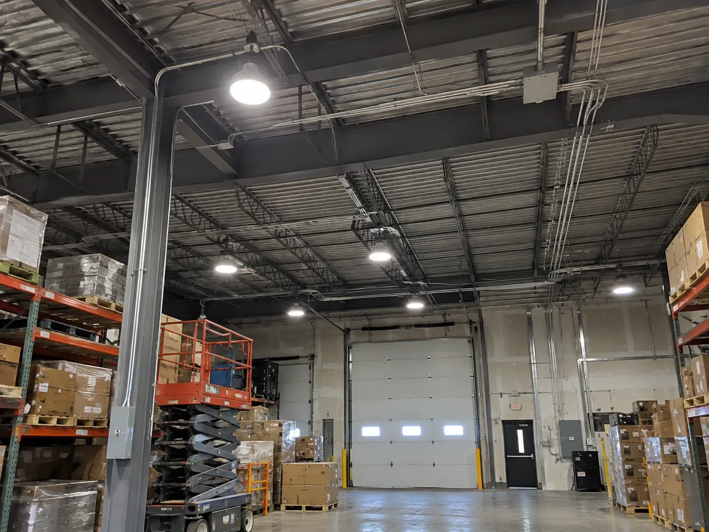 Warehouse with overhead industrial lighting and electrical infrastructure