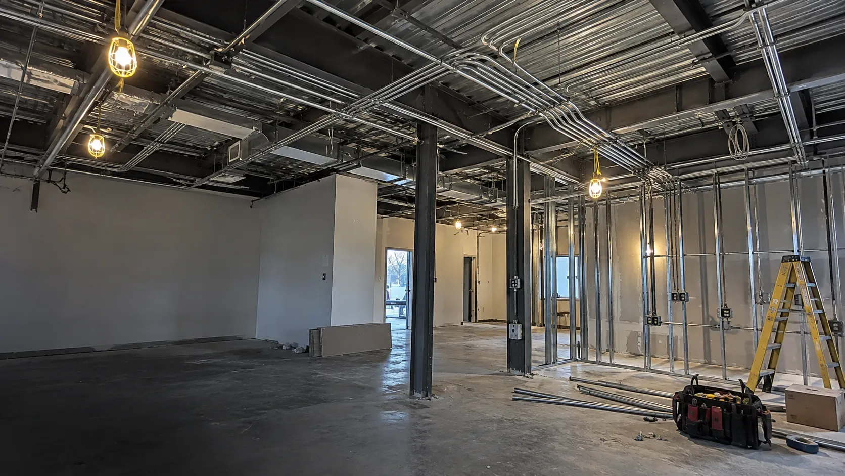 Commercial electrical fit-out with exposed ceiling framing, new conduit and electrical wiring